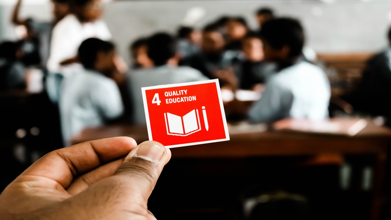Foto de uma mão segurando um papel ilustrando o ODS 4: educação de qualidade