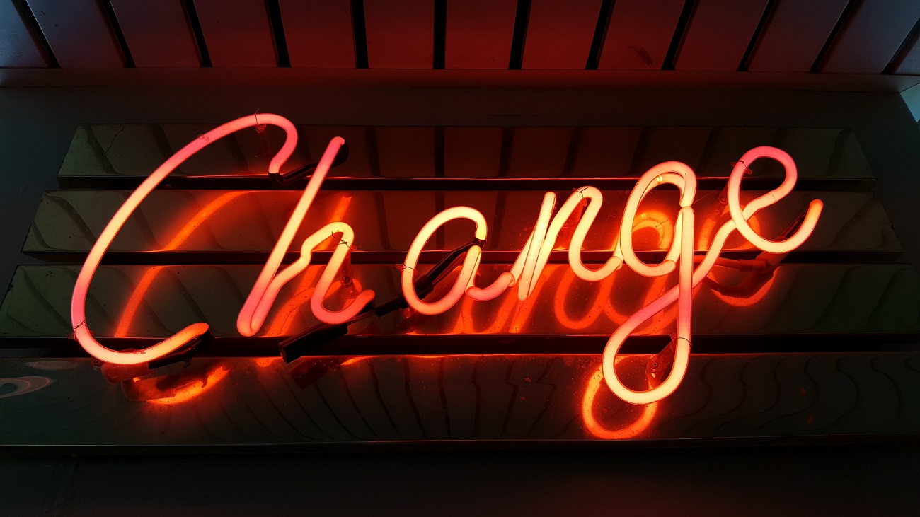 Foto da palavra change (mudança, em inglês) em neon em uma parede.